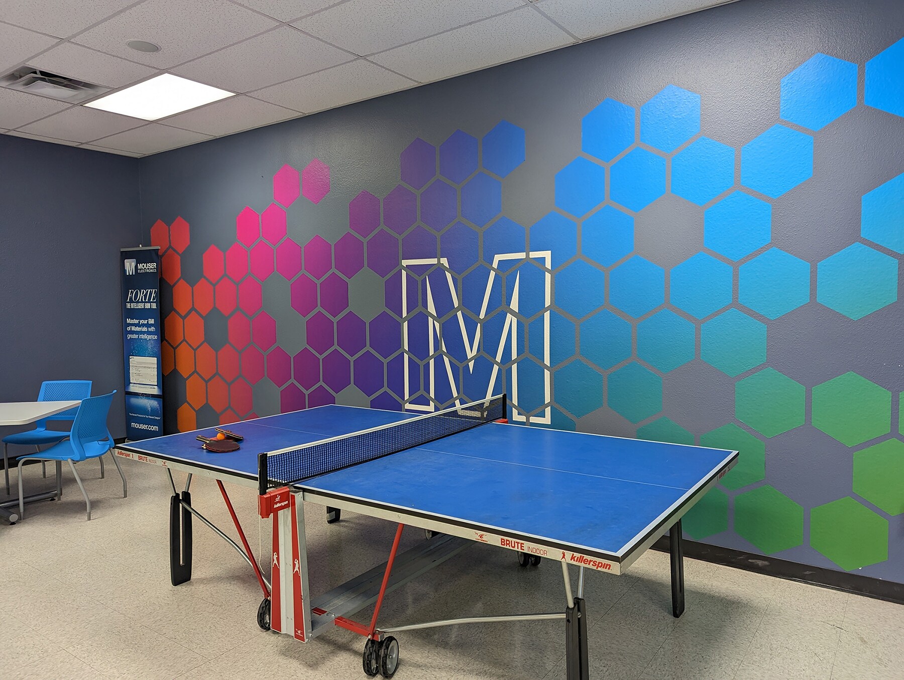 Colorful decal made of hexagons with a white outline of the letter M in the middle